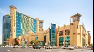 a large building with cars parked in a parking lot at Corniche AD - Luxury Room in Abu Dhabi