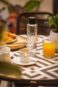 una mesa con una botella de zumo de naranja y una taza de café en Madeinterranea Suites, en Málaga