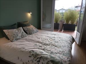 ein Bett in einem Schlafzimmer mit einem großen Fenster in der Unterkunft GARAT in Saint-Jean-de-Luz