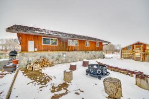 a house with a fire pit in the snow at Cody Vacation Rental Near Cedar Mountain! in Cody