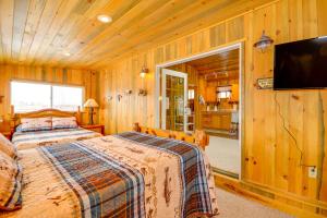 a bedroom with a bed and a flat screen tv at Cody Vacation Rental Near Cedar Mountain! in Cody
