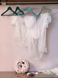 a rack of white dresses hanging on a wall at La piccola casa di Ubs in Sestri Levante