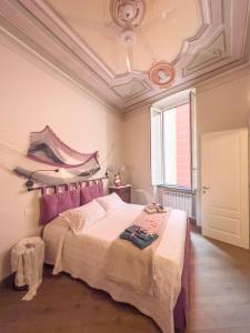 Schlafzimmer mit einem Bett mit rosa Kissen und einer Decke in der Unterkunft La piccola casa di Ubs in Sestri Levante