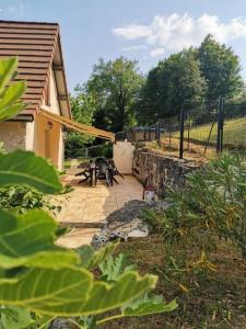 a patio with two picnic tables and a fence at LE MACHAON , Gîte rural *** avec espace piscine privé in Brégnier-Cordon