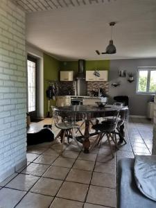 uma cozinha com mesa e cadeiras num quarto em LE MACHAON , Gîte rural *** avec espace piscine privé em Brégnier-Cordon