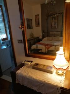 モンサーノにあるLe Stanze di Rosaの鏡付きベッドルームのテーブル上のランプ