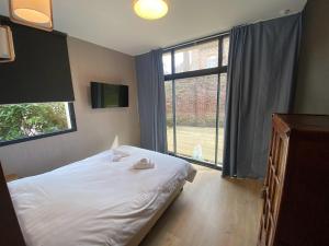 a bedroom with a bed and a large window at Parc Beausejour Aparthotel in Dieppe