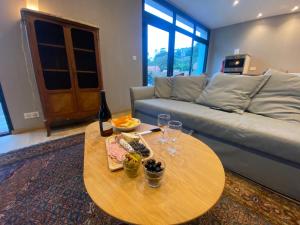 een woonkamer met een bank en een tafel met wijnglazen bij Parc Beausejour Aparthotel in Dieppe