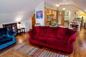 a living room with a red couch and a table at Boys Dormitory in Fort Augustus