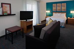 a hotel room with a bed and a couch and a tv at Residence Inn Shelton Fairfield County in Shelton