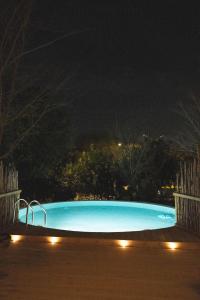una piscina azul por la noche con luces en Slowness - Kibbutz Moran en Moran