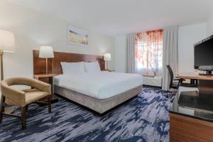 a hotel room with a bed and a chair and a television at Fairfield Inn & Suites Houston Westchase in Houston