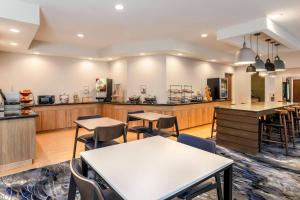 un restaurante con mesas y sillas y una cocina en Fairfield Inn & Suites Houston Westchase en Houston