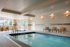 einen Pool in einem Hotel mit Stühlen und einem Tisch in der Unterkunft Courtyard by Marriott Glenwood Springs in Glenwood Springs