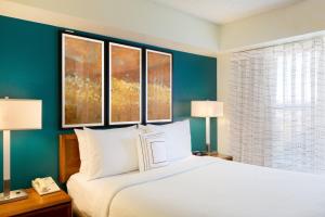 1 dormitorio con 1 cama con 2 lámparas y 2 ventanas en Residence Inn by Marriott Austin Parmer/Tech Ridge, en Austin