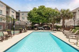 a swimming pool with chairs and a building at Residence Inn by Marriott Austin Parmer/Tech Ridge in Austin