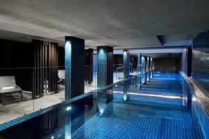 a swimming pool in a hotel with blue tiles at Midnight Hotel, Autograph Collection in Canberra