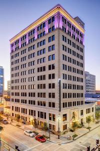 a large white building with purple lights on it at WATERMARK Baton Rouge, Autograph Collection in Baton Rouge