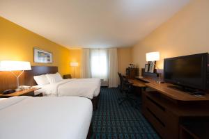 a hotel room with two beds and a flat screen tv at Fairfield Inn & Suites Burlington in Burlington