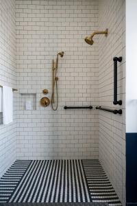 y baño con ducha de azulejos blancos y negros. en WATERMARK Baton Rouge, Autograph Collection en Baton Rouge