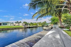 ein Kanal mit einer Palme und einem Boot in der Unterkunft Water Front Home with Boat Dock Hot Tub Roof Top Fire Pit in Fort Lauderdale