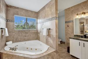 ein großes Badezimmer mit Badewanne und Fenster in der Unterkunft Water Front Home with Boat Dock Hot Tub Roof Top Fire Pit in Fort Lauderdale + 39 Fotos