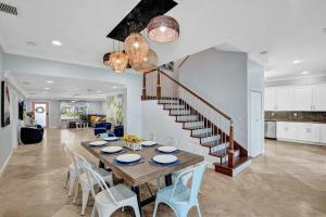 ein Esszimmer mit Tisch und Stühlen und einer Treppe in der Unterkunft Water Front Home with Boat Dock Hot Tub Roof Top Fire Pit in Fort Lauderdale
