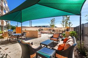 un patio con muebles y una gran sombrilla verde en Residence Inn by Marriott Austin Northwest/The Domain Area, en Austin