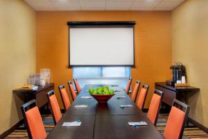 una sala de conferencias con una mesa larga y un bol de fruta en Fairfield Inn & Suites by Marriott Bridgewater Branchburg/Somerville en Branchburg Park
