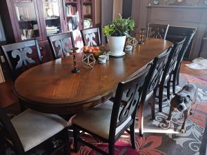 a dog standing at a wooden table in a dining room at Blue Ruby at Grice-Fearing B&B in Elizabeth City