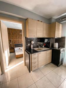 a kitchen with wooden cabinets and a sink and a stove at Luxury Equiped Apartment - Olympic Beach in Olympiaki Akti