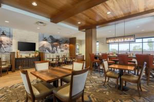 a restaurant with wooden tables and chairs and a fireplace at Fairfield Inn & Suites by Marriott Cheyenne Southwest/Downtown Area in Cheyenne