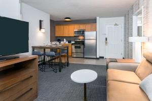 a living room and kitchen with a couch and a tv at Residence Inn Wayne in Wayne