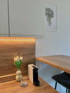a table with a vase of flowers and a toaster at Apartment Olive in Białołęka-Tarchomin Center in Warsaw