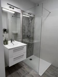 bagno bianco con doccia e lavandino di Apartment Olive in Białołęka-Tarchomin Center a Varsavia