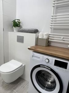 a bathroom with a washing machine and a toilet at Apartment Olive in Białołęka-Tarchomin Center in Warsaw