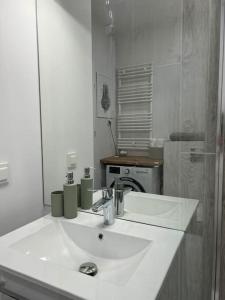 a white bathroom with a sink and a mirror at Apartment Olive in Białołęka-Tarchomin Center in Warsaw
