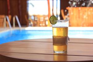 un vaso de cerveza sentado en una mesa junto a una piscina en Cabaña Yalis SAS, en Cartagena de Indias