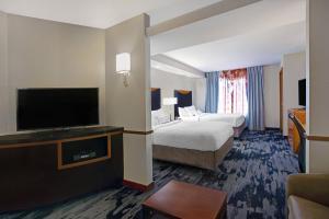 a hotel room with two beds and a flat screen tv at Fairfield Inn and Suites Carlsbad in Carlsbad