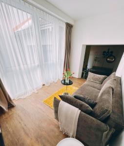 a living room with a couch and a large window at Castle Apartaments host Kaunas with free parking in Kaunas