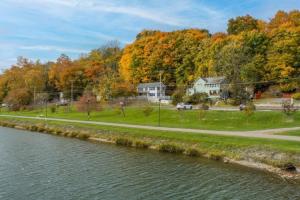 eine Straße neben einem Fluss mit Häusern und Bäumen in der Unterkunft River Front Home In the Heart of Ithaca in Ithaca