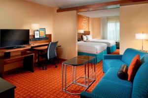 a hotel room with a couch and a bed and a desk at Fairfield Inn & Suites by Marriott Fayetteville North in Fayetteville