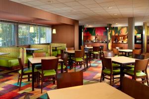 a restaurant with tables and chairs and a bar at Fairfield Inn & Suites by Marriott Fayetteville North in Fayetteville