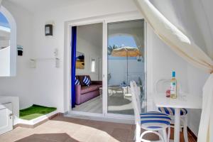 Sala de estar con mesa y sillas y vistas al océano en Neptuno Bungalows - Adults Only, en Corralejo