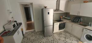 a small kitchen with a refrigerator and a sink at maison de village rogliano / macinaggio cap corse in Rogliano