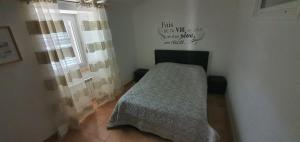 a small bedroom with a bed and a window at maison de village rogliano / macinaggio cap corse in Rogliano