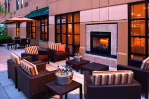 a patio with chairs and tables and a fireplace at Courtyard Cincinnati Covington in Covington