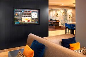 卡溫頓的住宿－辛辛那提科文頓萬怡酒店，客厅配有沙发和墙上的电视