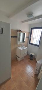 a bathroom with a white sink and a window at maison de village rogliano / macinaggio cap corse in Rogliano