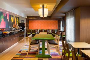 a dining room with a green table and chairs at Fairfield Inn & Suites Naperville/Aurora in Naperville